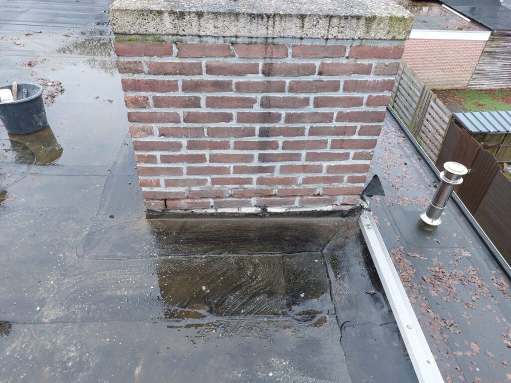 De openstaande rand van de dakbedekking is niet hoog genoeg, waardoor een schoorsteenlekkage ontstaat. Schoorsteen lood vervangen? JTS Bouw is de schoorsteen specialist.